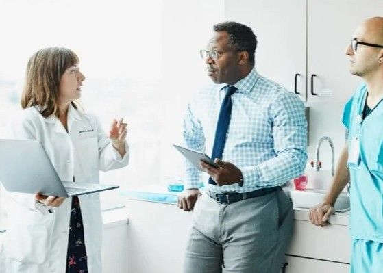 healthcare consultant talking to two doctors
