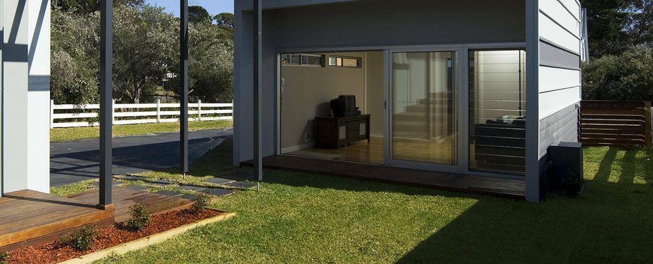 House With A Large Sliding Glass Door On Top Of A Lush Green Lawn — Atherton Glass In Atherton, QLD