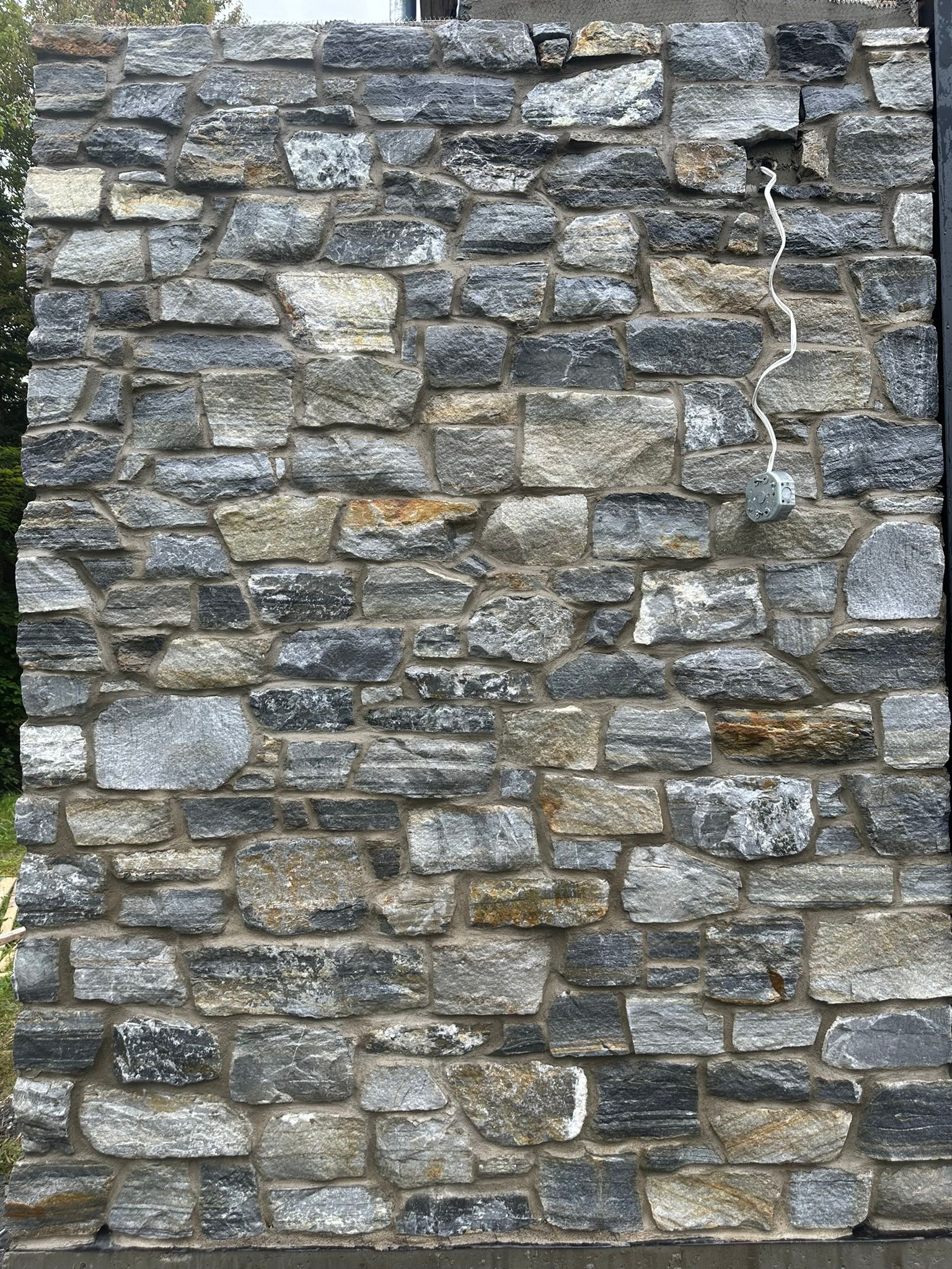 Mur en briques de pierre grises, bleues et beiges.