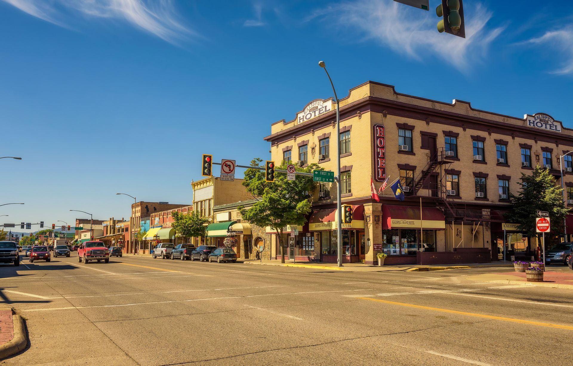 Sunny downtown street with historic buildings, shops, and traffic lights at an empty intersection