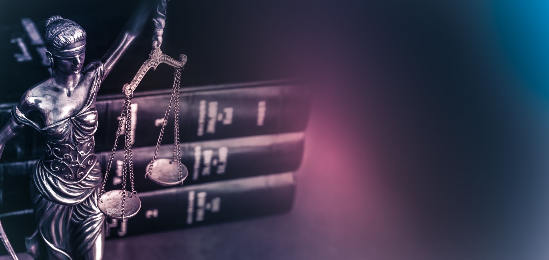 A statue of justice is standing in front of a stack of books.