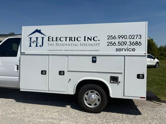 White utility truck with HJ Electric Inc. logo and contact numbers on the side.