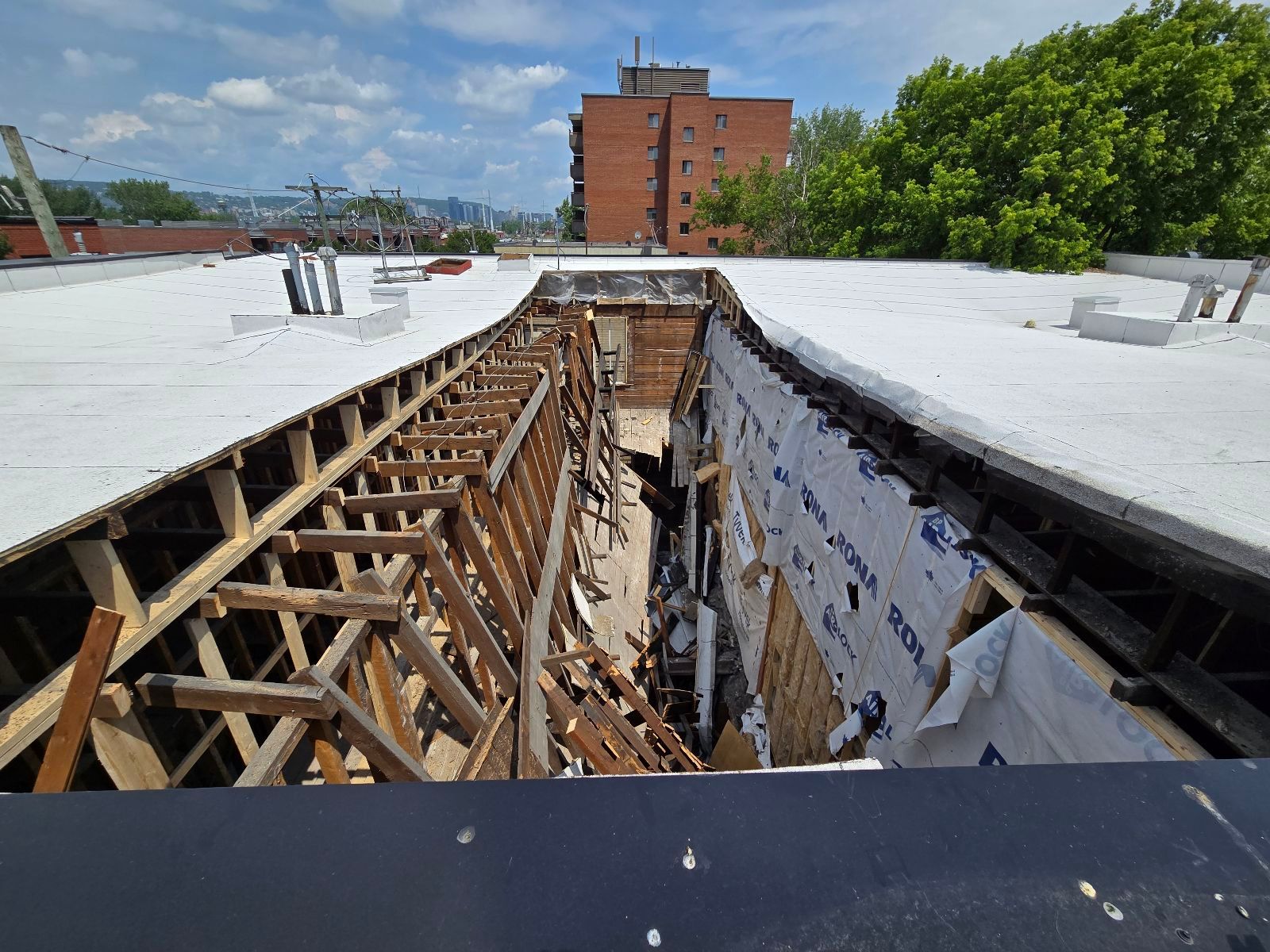 Un grand bâtiment est en train d'être démoli avec beaucoup de machines.