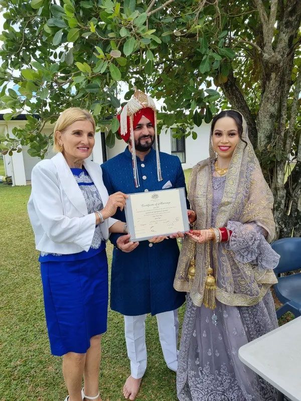 A Woman is Giving a Certificate to a Bride and Groom โ GinaS Cairns Tropical Weddings in Parramatta Park, QLD