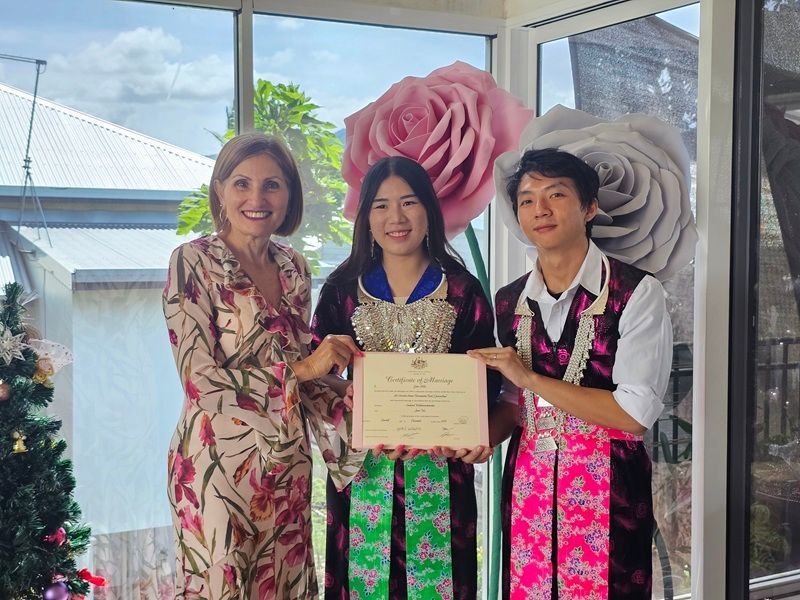 Three people holding a certificate, with large flowers behind — GinaS Cairns Tropical Weddings in Parramatta Park, QLD