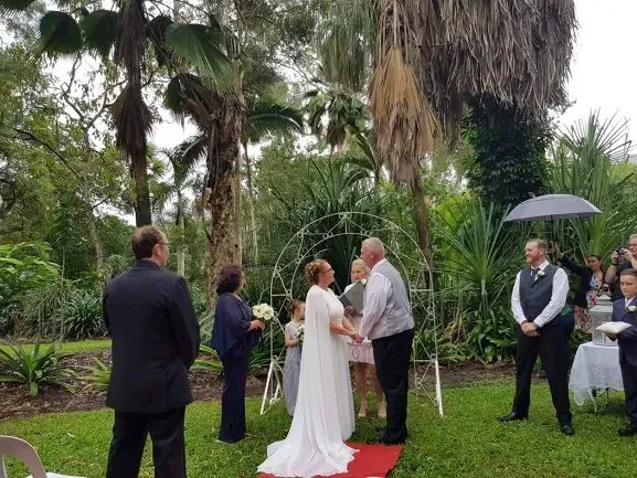 A Bride and Groom Are Holding Hands During Their Wedding Ceremony โ GinaS Cairns Tropical Weddings in Parramatta Park, QLD