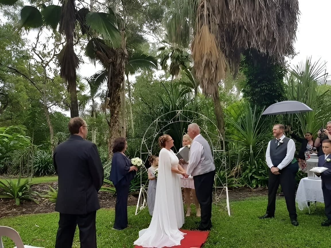 A Bride and Groom Are Holding Hands During Their Wedding Ceremony — GinaS Cairns Tropical Weddings in Port Douglas, QLD