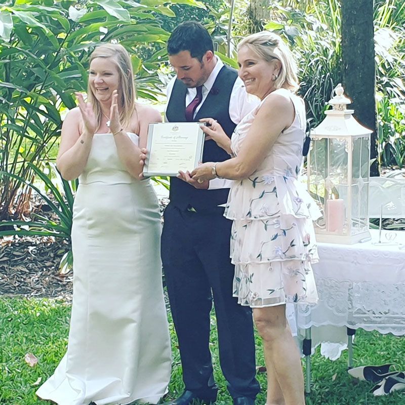 A Bride and Groom Standing Next to Each Other Holding a Certificate โ GinaS Cairns Tropical Weddings in Parramatta Park, QLD