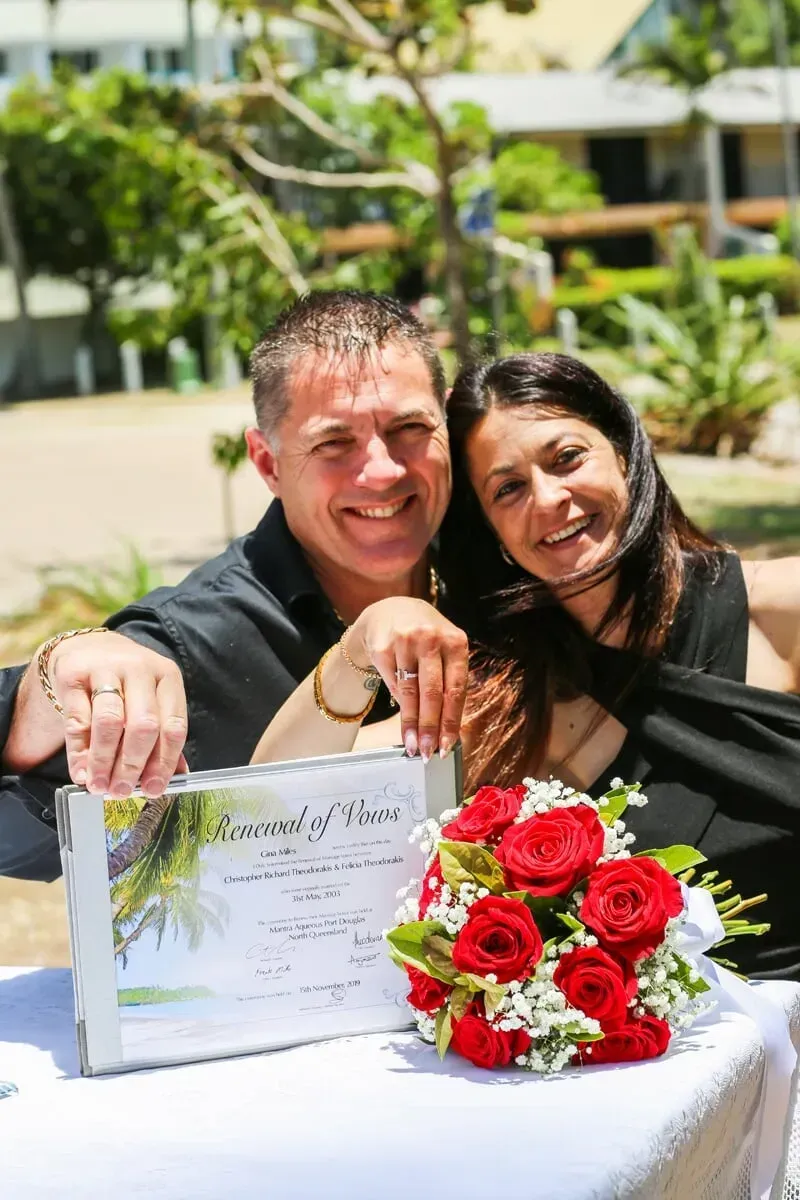 A Man and a Woman Are Sitting at a Table With a Bouquet of Red Roses โ GinaS Cairns Tropical Weddings in Parramatta Park, QLD