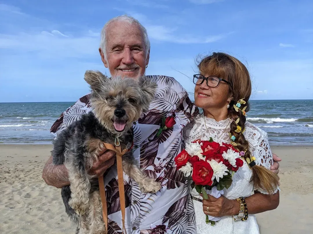 A Man and Woman Are Posing for a Picture With Their Dog on the Beach โ GinaS Cairns Tropical Weddings in Parramatta Park, QLD