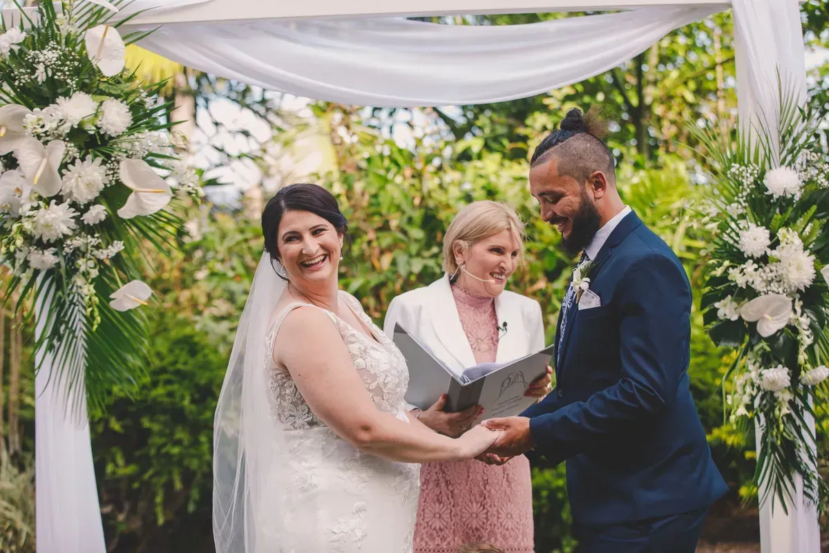 A Bride and Groom Are Holding Hands During Their Wedding Ceremony โ GinaS Cairns Tropical Weddings in Parramatta Park, QLD