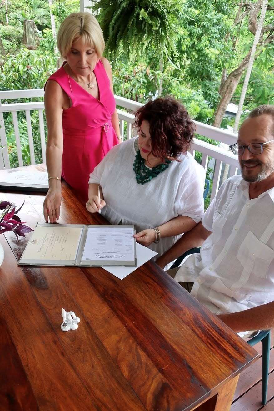 Marriage Celebrant In Cairns Signing Marriage Documents With Couple