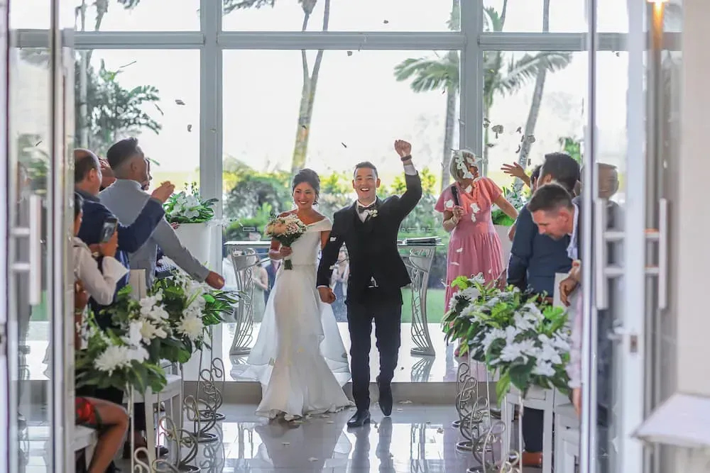 A Bride and Groom Are Walking Down the Aisle at Their Wedding โ GinaS Cairns Tropical Weddings in Parramatta Park, QLD