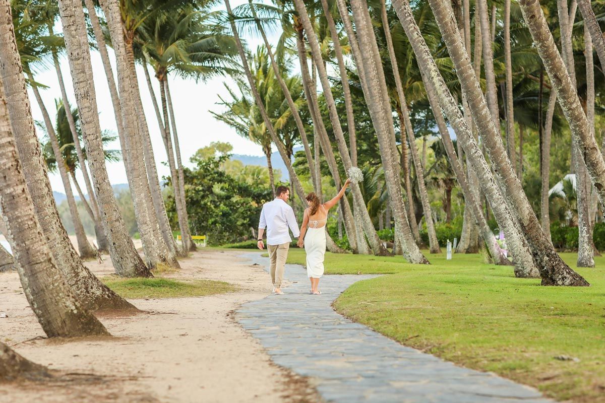 Couple Walking Hand in Hand on A Palm-Lined Path Near a Beach — GinaS Cairns Tropical Weddings in Parramatta Park, QLD