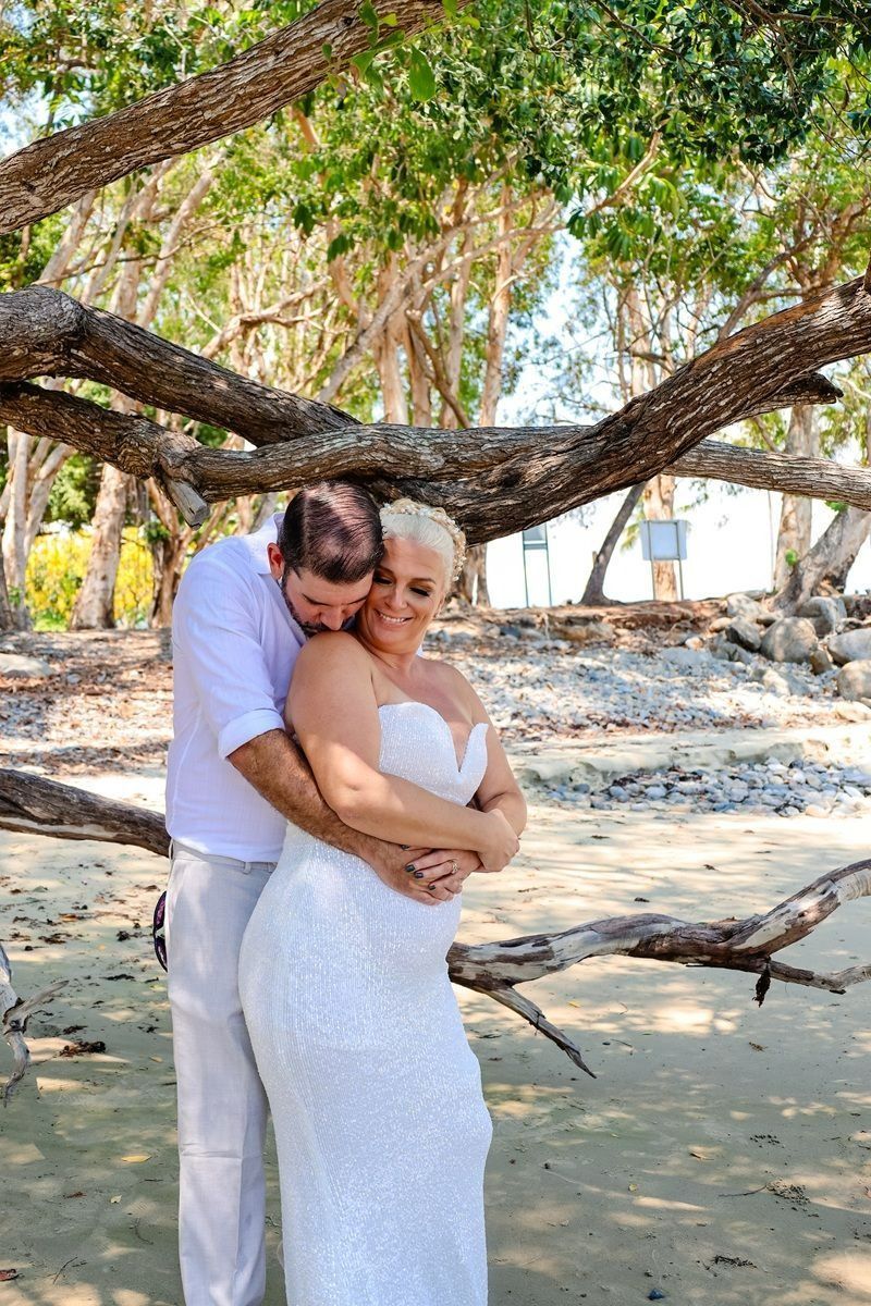 Couple Embracing Under a Tree on A Sandy Beach and Dressed in White — GinaS Cairns Tropical Weddings in Parramatta Park, QLD