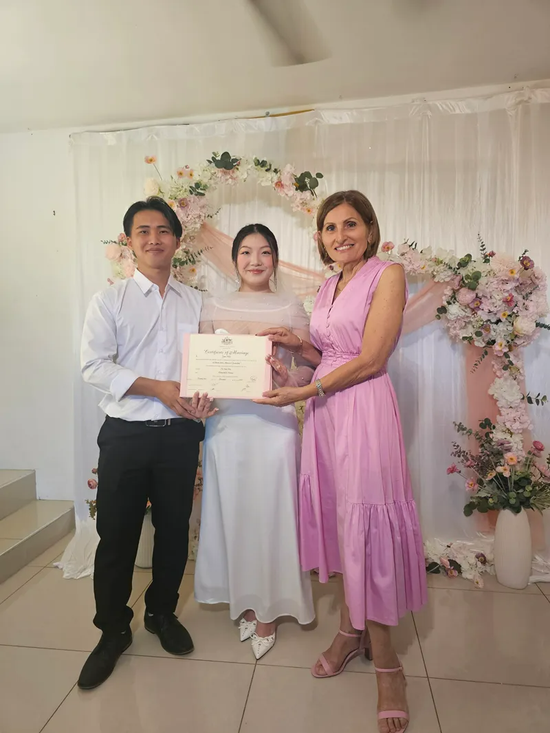 Pa and Khouachalee wih Gina Posing with A Certificate at A Floral Celebration Backdrop — GinaS Cairns Tropical Weddings in Parramatta Park, QLD