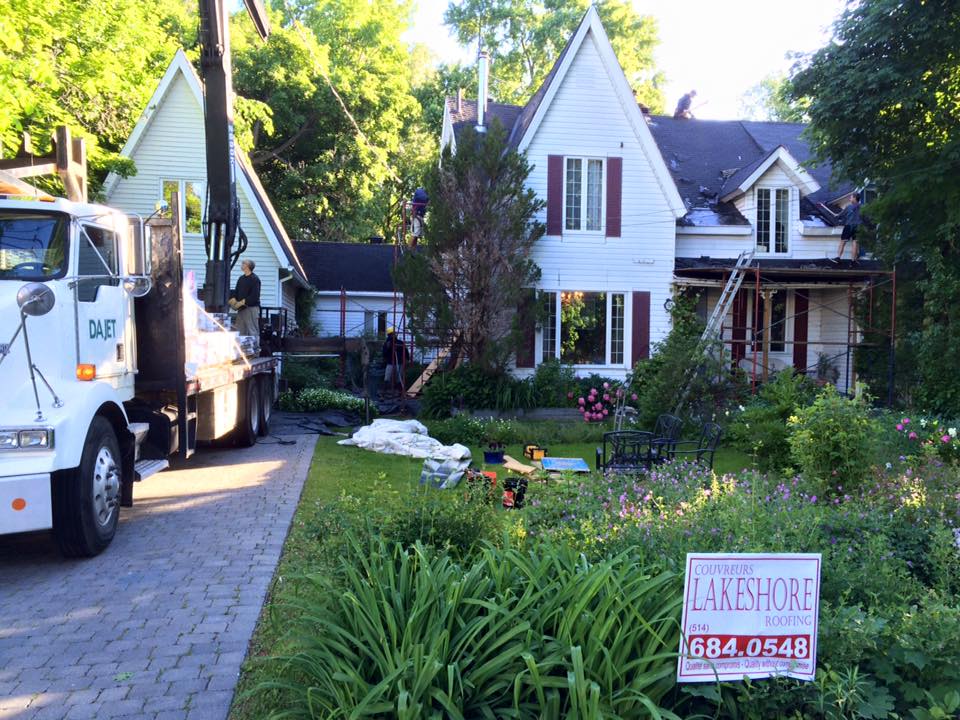 Maison en construction avec camion-grue, jardin devant. Panneau indiquant Lakeshore.