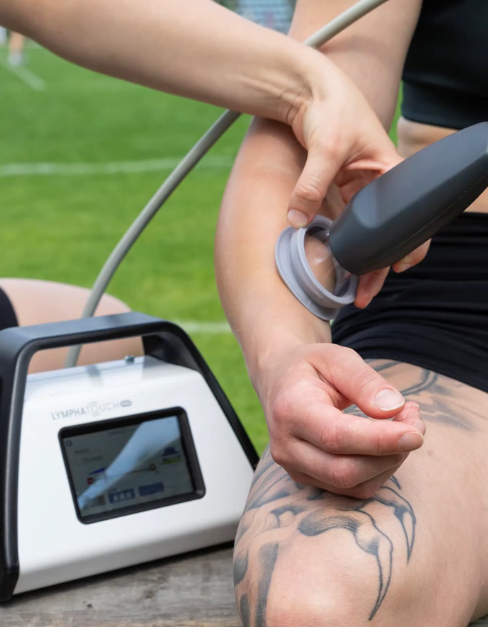 Ultrasound therapy device applied to a tattooed leg on a sports field