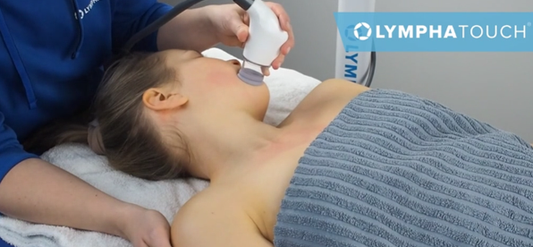 Person receiving a facial treatment with a handheld device in a spa setting