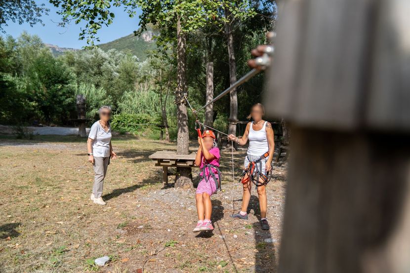 Ragazzo su ponte tibetano tra gli alberi