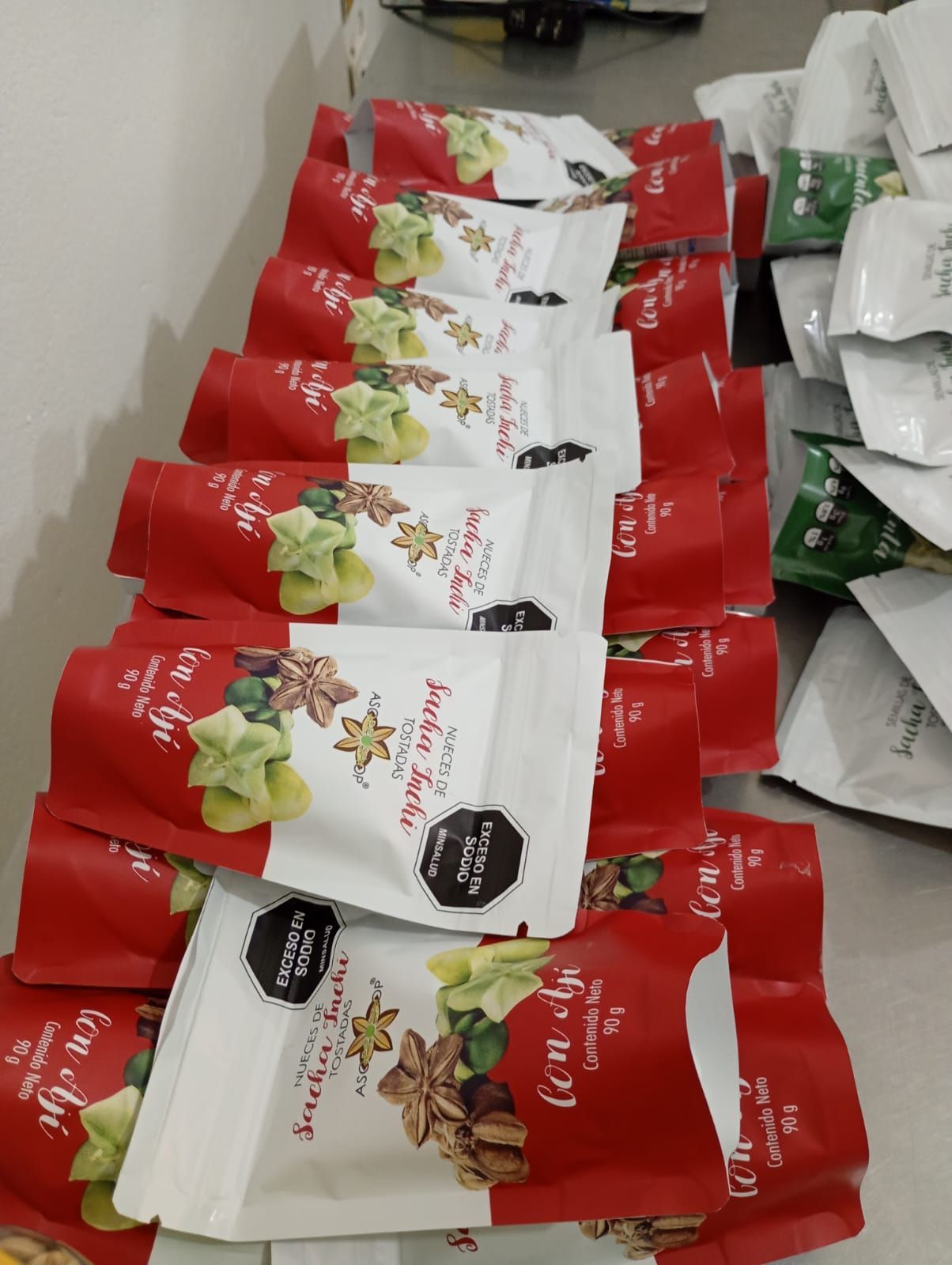 Bolsas de aperitivos rojas y blancas apiladas ordenadamente en un estante.