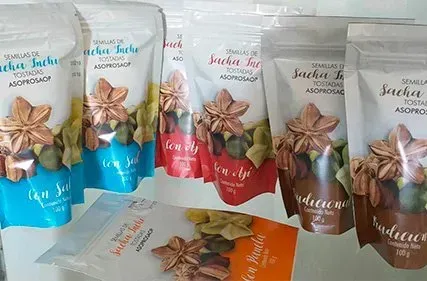 Bolsitas surtidas de snacks de sacha inchi en envases azules, blancos, rosas y marrones sobre una mesa.