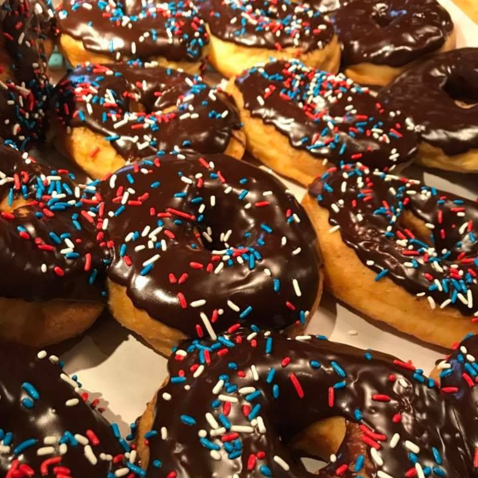 Chocolate frosted donuts with red, white, and blue sprinkles.