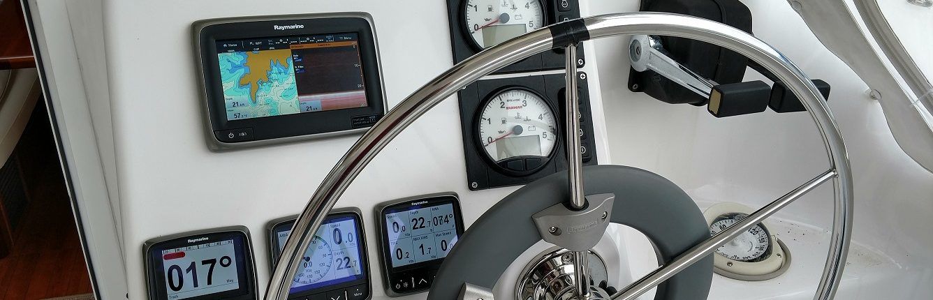 Boat's helm with navigation screens, gauges, and a steering wheel.