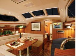 Interior of a boat with wooden paneling, a dining table set, windows, and a TV.