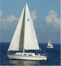 White sailboat on blue water, another in the distance, under a bright, partly cloudy sky.