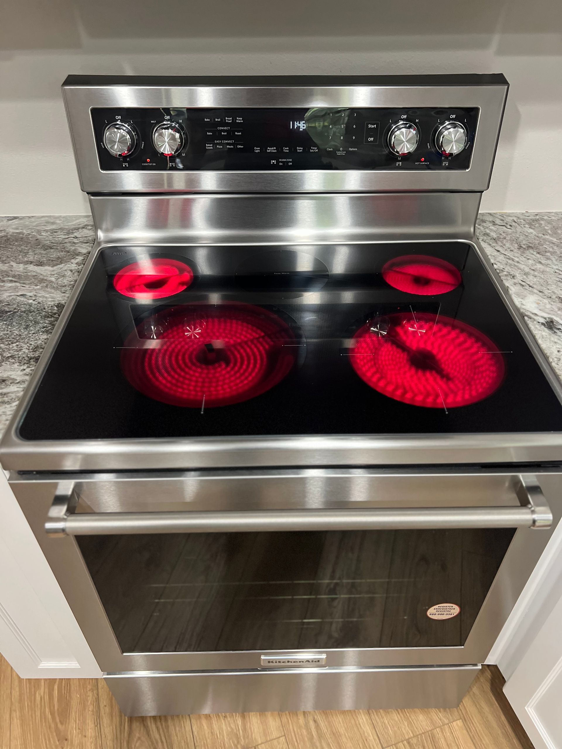 A stainless steel stove with a red burner on top of it.