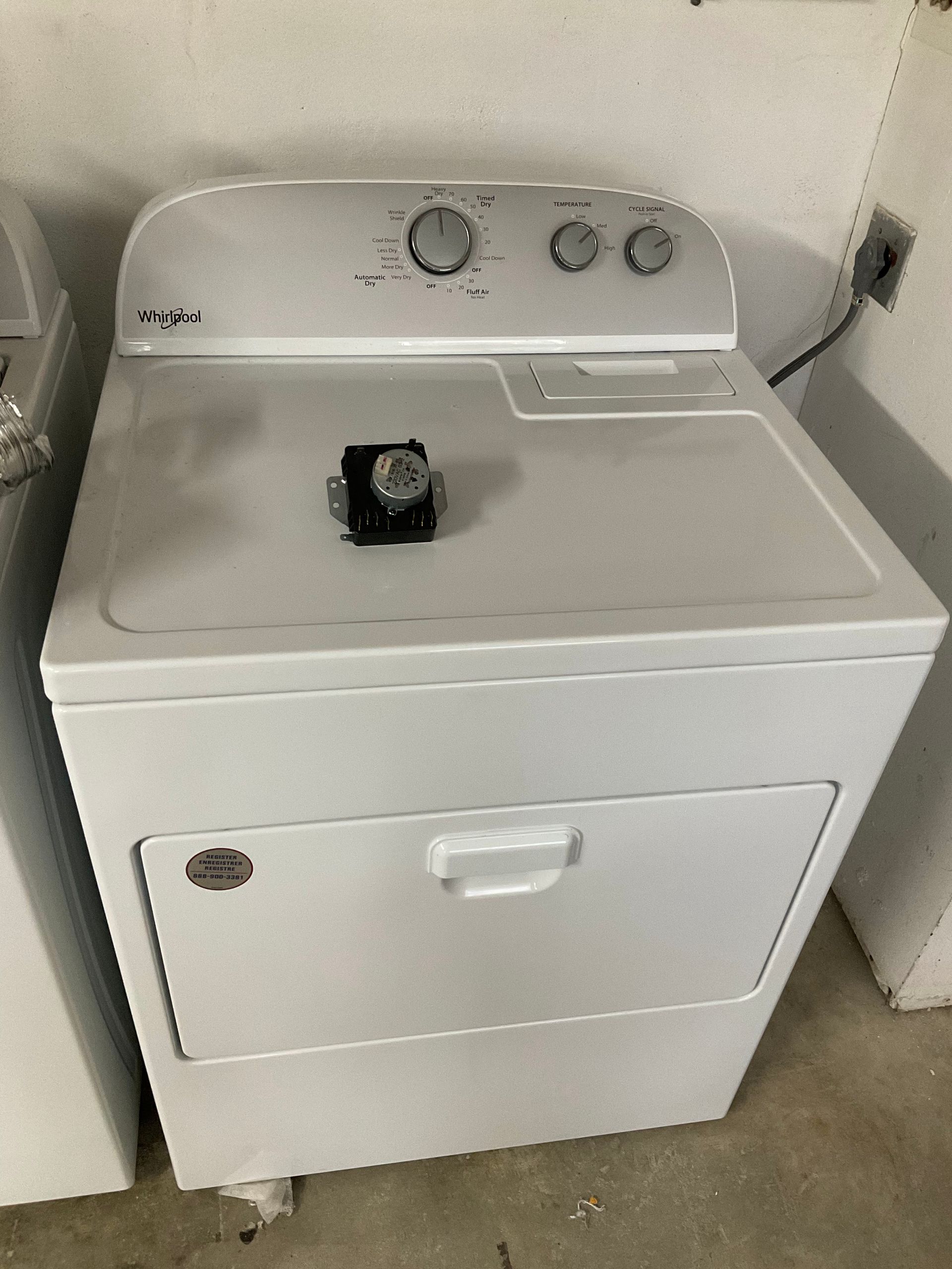 A white washer and dryer are sitting next to each other in a laundry room.