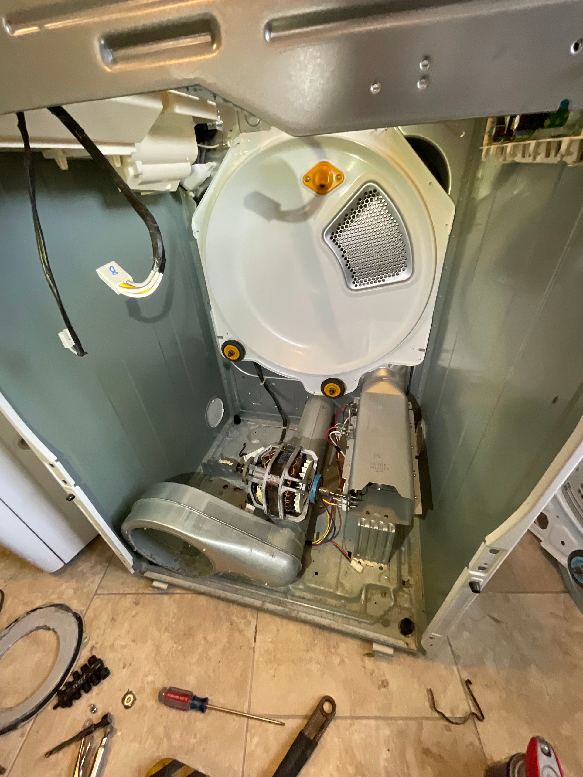 The inside of a washer and dryer is being repaired.