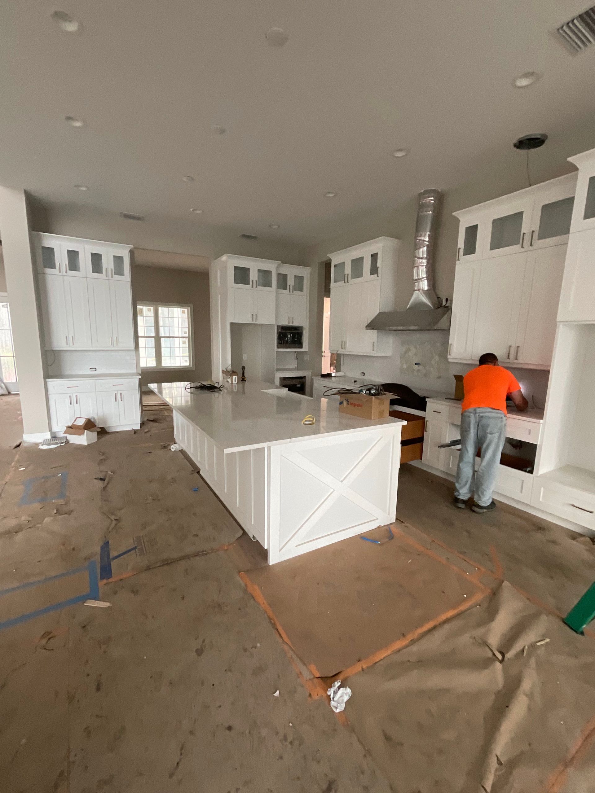 A man is working on a kitchen in a house under construction.