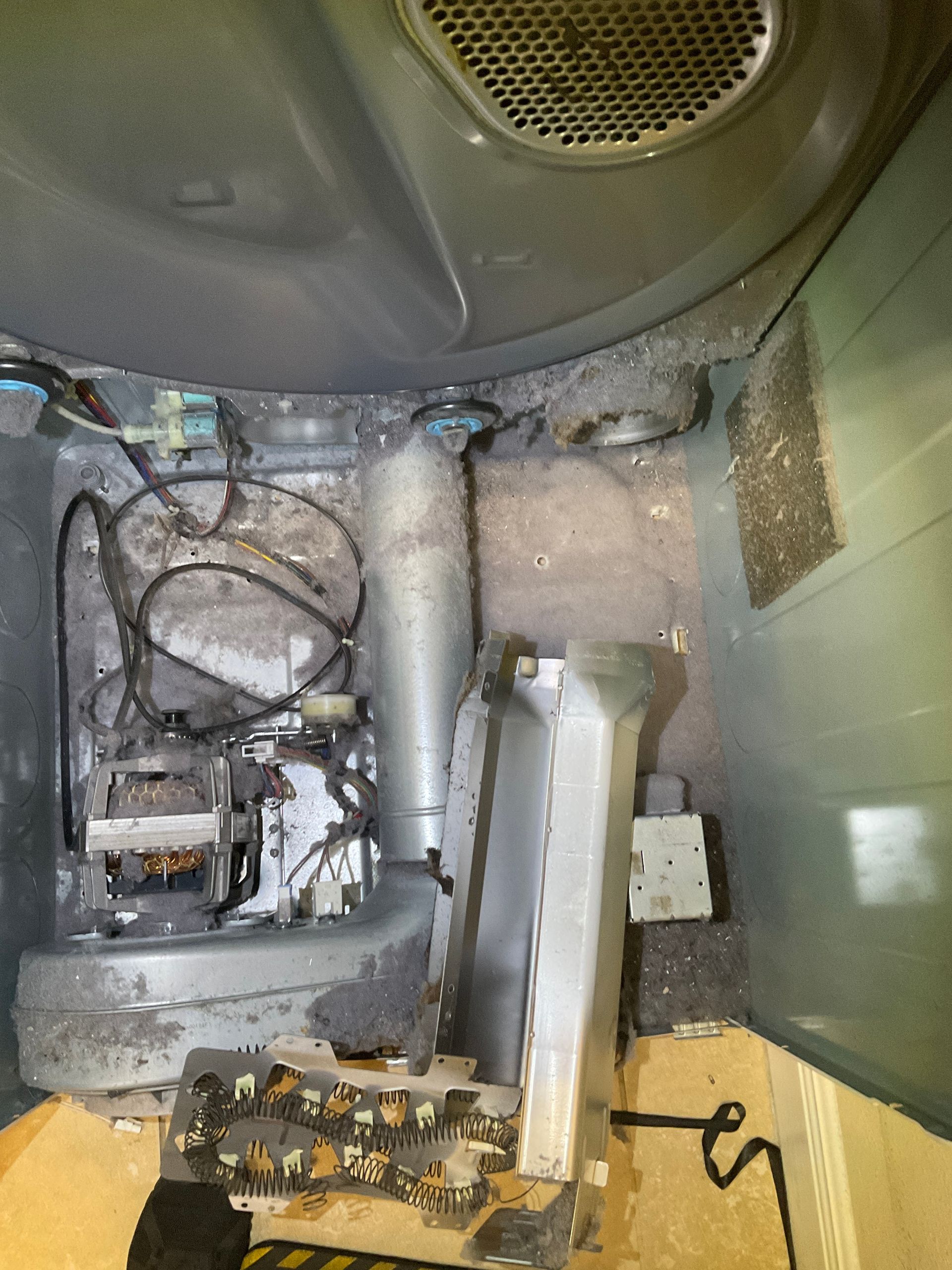 The inside of a dryer is covered in dust and dirt.