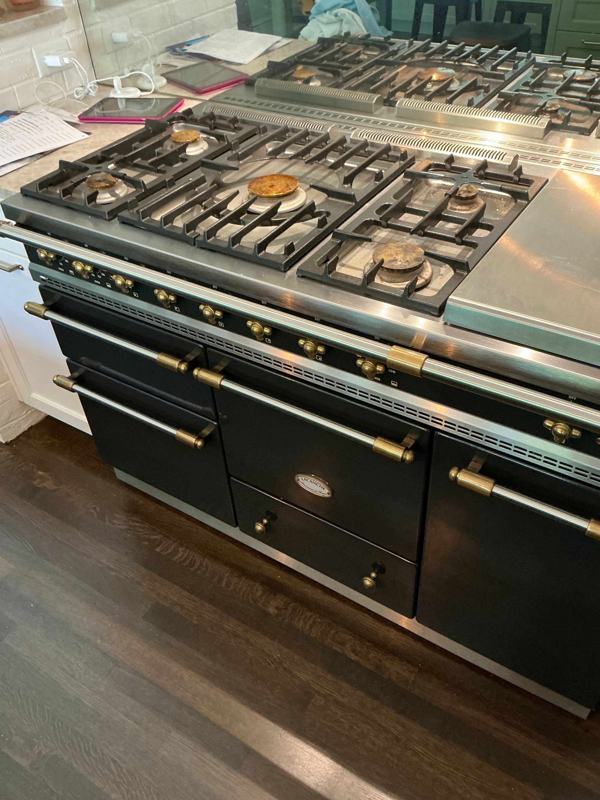 A stove top oven is sitting on top of a wooden counter in a kitchen.