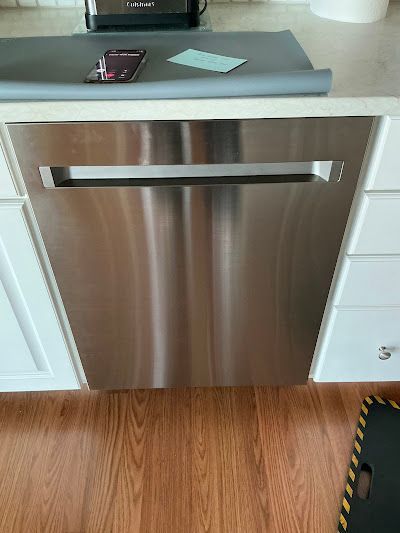 A stainless steel dishwasher is sitting under a counter in a kitchen.