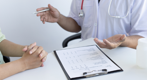 Doctor discussing chart with patient across desk