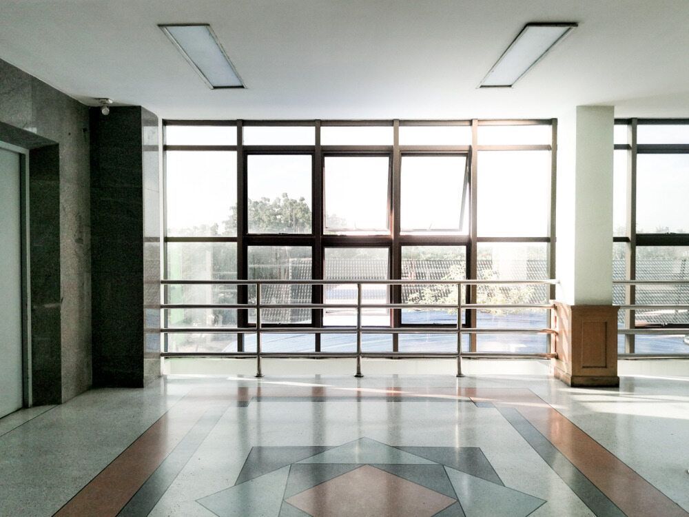 A Hallway With a Lot of Windows and a Patterned Floor — Accurate Fitout Solutions In Wetherill Park, NSW