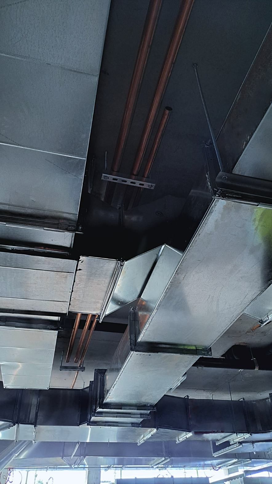 A Ceiling With a Lot of Pipes Hanging From It — Accurate Fitout Solutions In Wetherill Park, NSW
