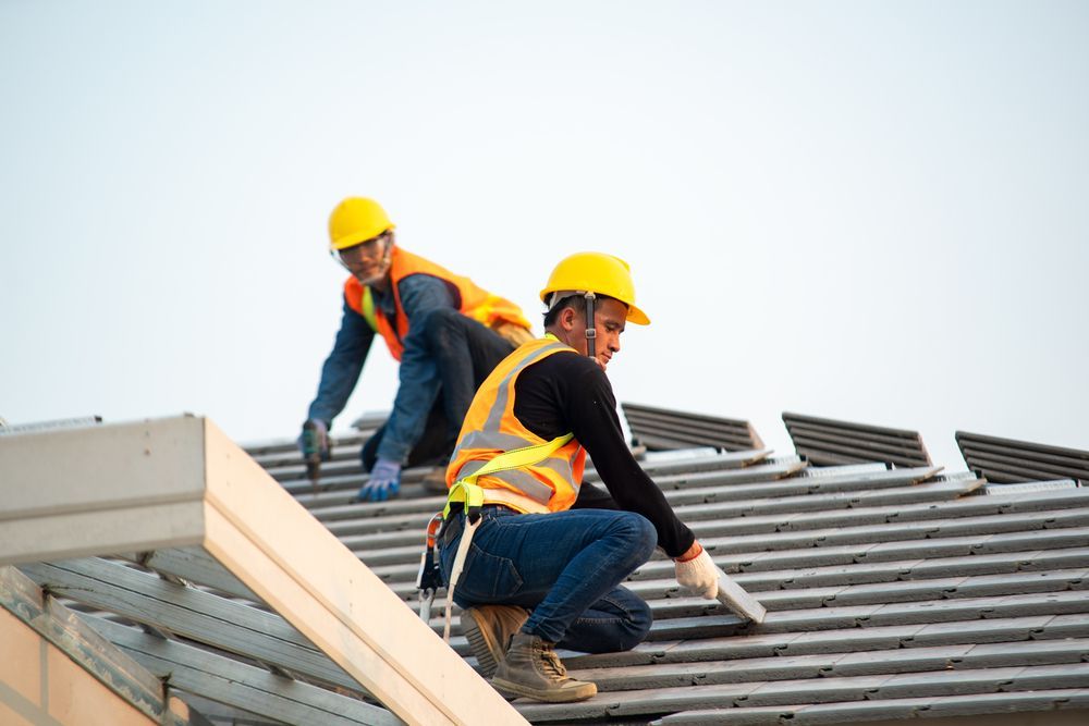 Two Construction Workers Are Working on the Roof of a Building — Accurate Fitout Solutions In Wetherill Park, NSW