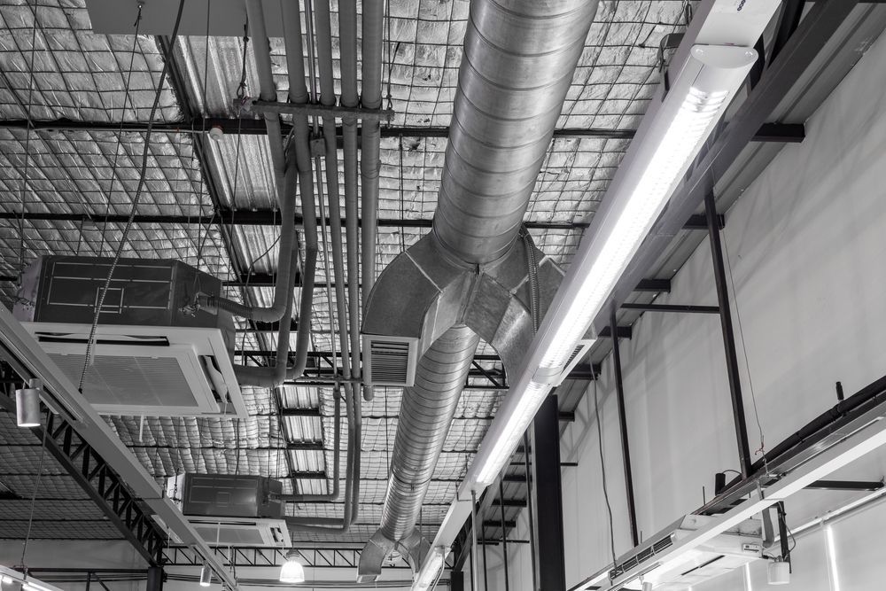 A Black and White Photo of a Ceiling With a Lot of Pipes and Lights — Accurate Fitout Solutions In Auburn, NSW