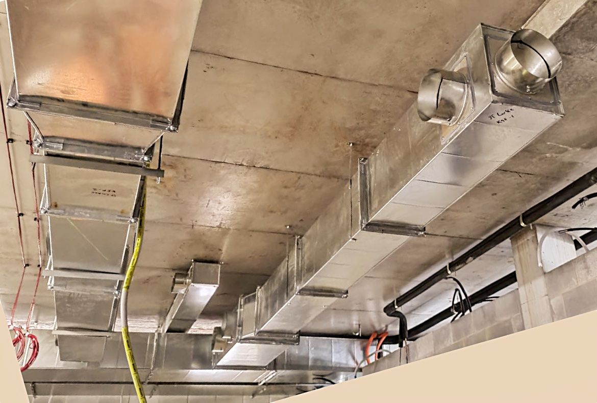 A Bunch of Metal Pipes Are Hanging From the Ceiling of a Building — Accurate Fitout Solutions In Mascot, NSW