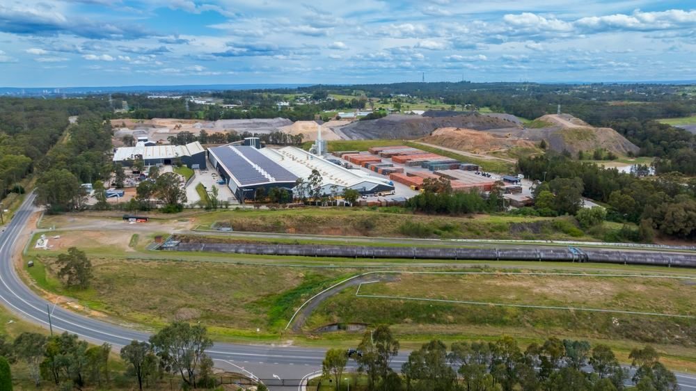 An Aerial View of a Large Industrial Area Surrounded by Trees and a Road — Accurate Fitout Solutions In Eastern Creek, NSW
