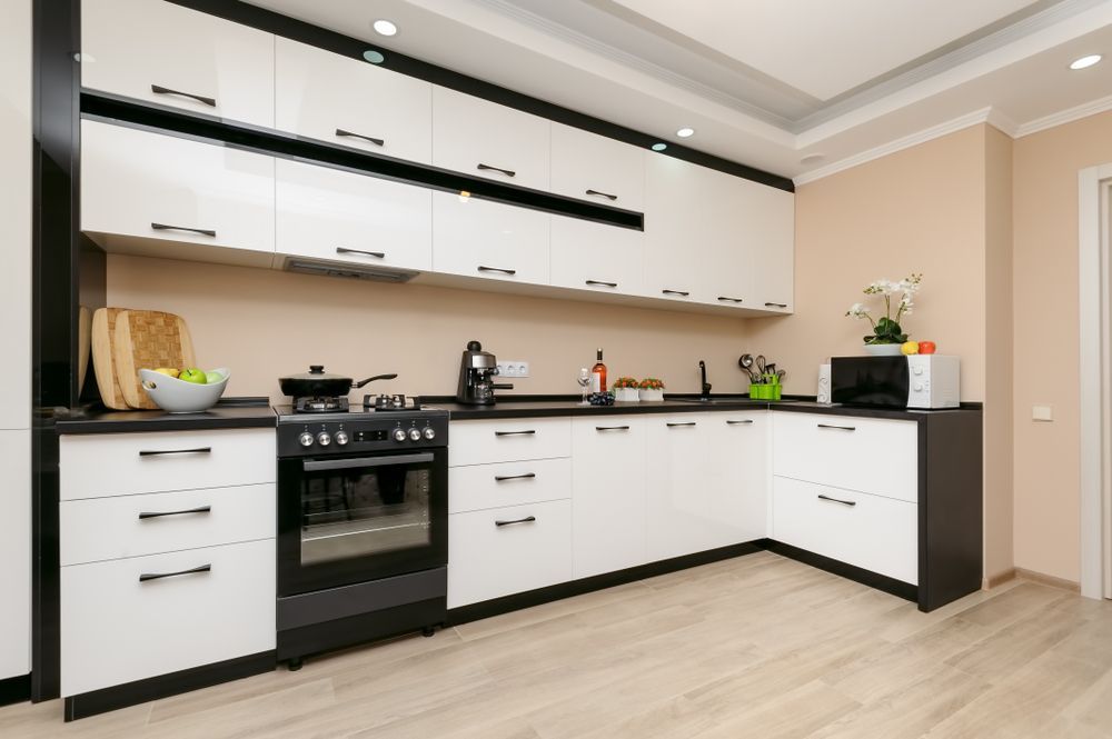 A Kitchen With Black And White Cabinets And A Stove — The Right Kitchen Company in Albion Park, NSW