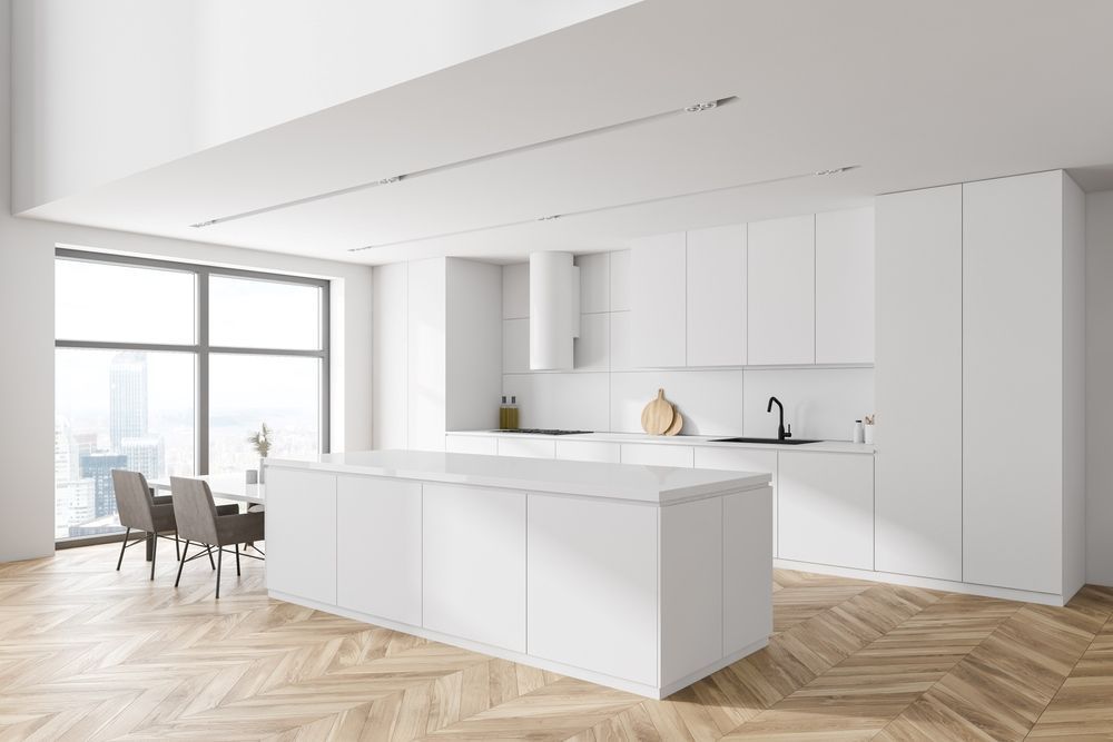 A Kitchen With White Cabinets And A Large Island In The Middle — The Right Kitchen Company in Dapto, NSW
