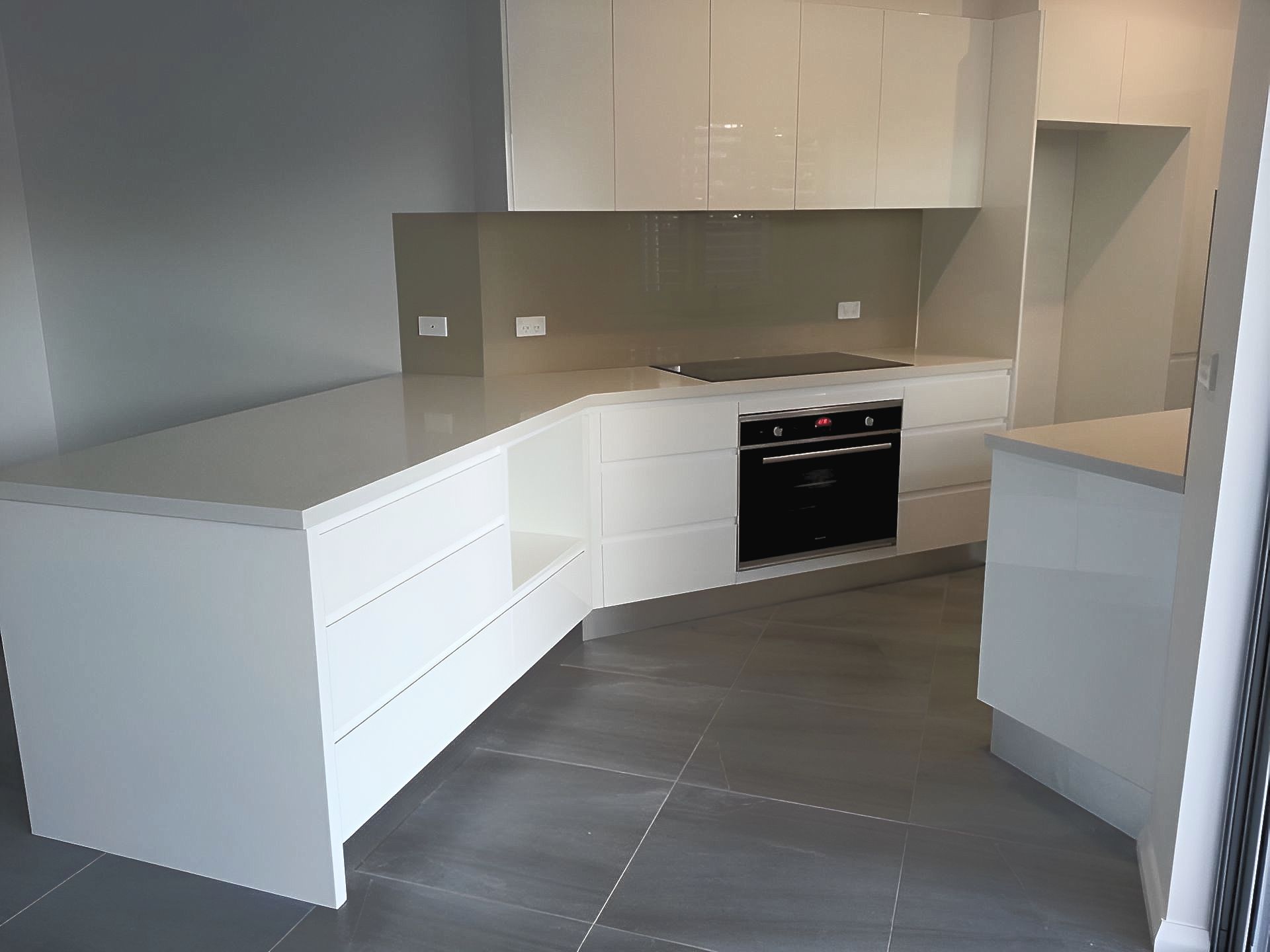 A white kitchen with dark tiled floors — The Right Kitchen Company In Berkeley, NSW
