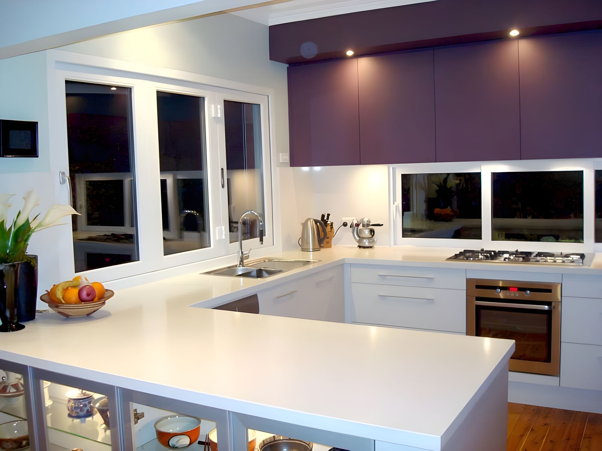 a kitchen with white benches and plum coloured feature wall  — The Right Kitchen Company In Berkeley, NSW