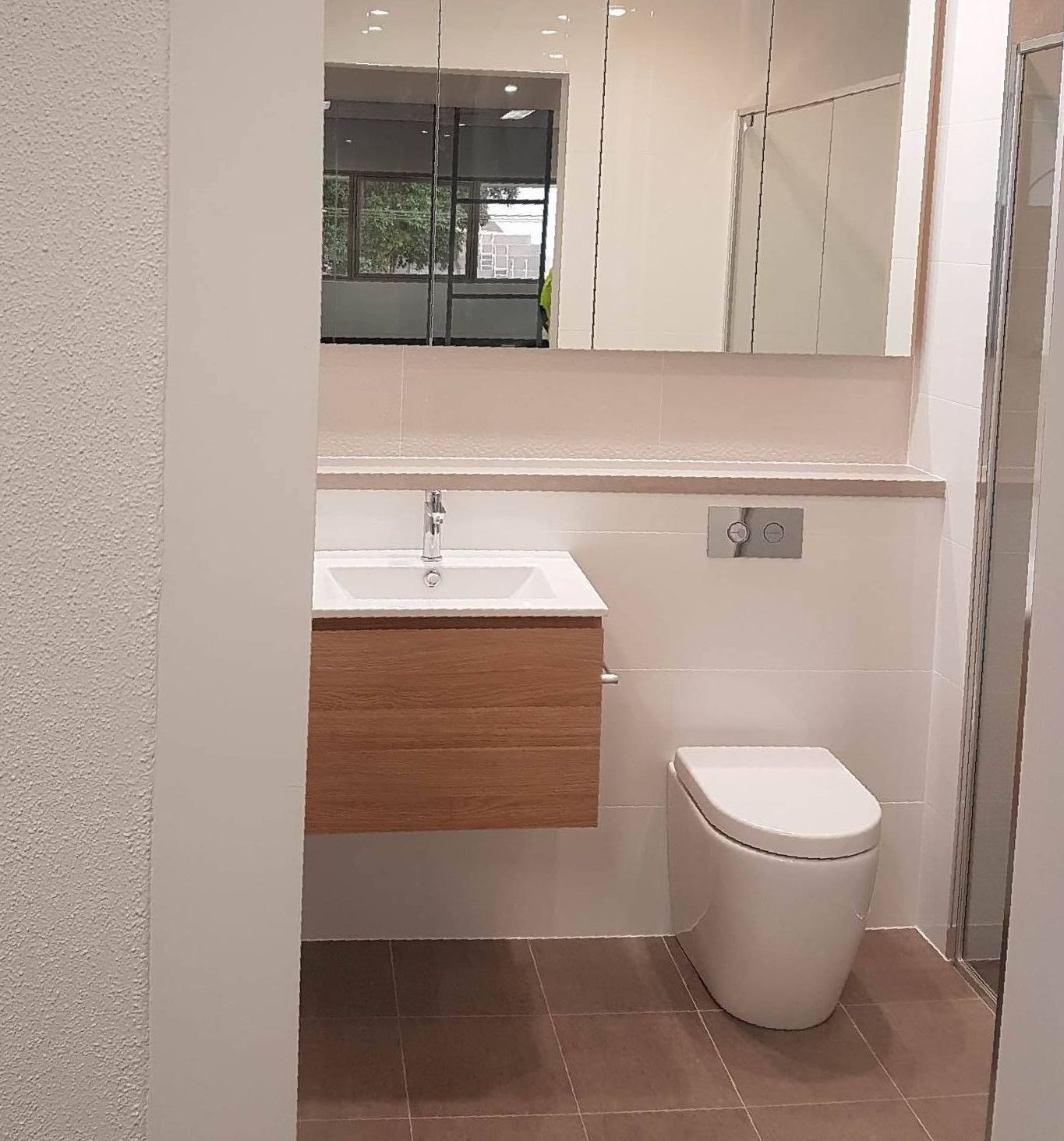 a bathroom with wooden vanity drawers and mirrors — The Right Kitchen Company In Berkeley, NSW