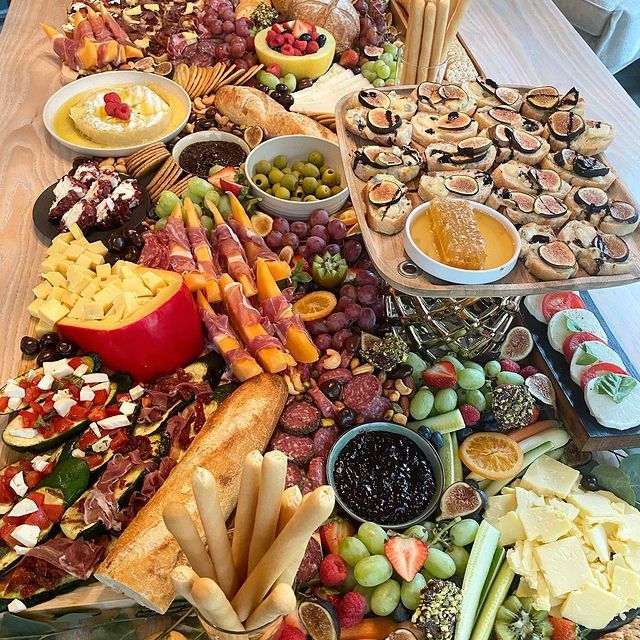 A wooden table topped with a variety of food including fruits and vegetables